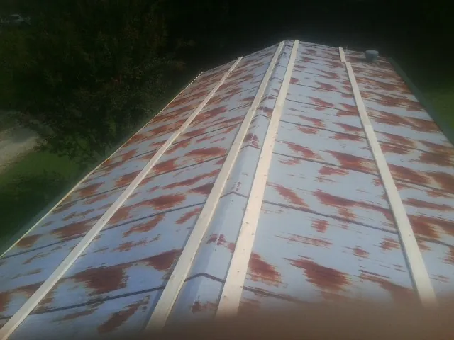 Rusted metal roof panels with new wood purlins before replacement — Storm Damage Roof Repair in Spicer by Roofing Brothers
