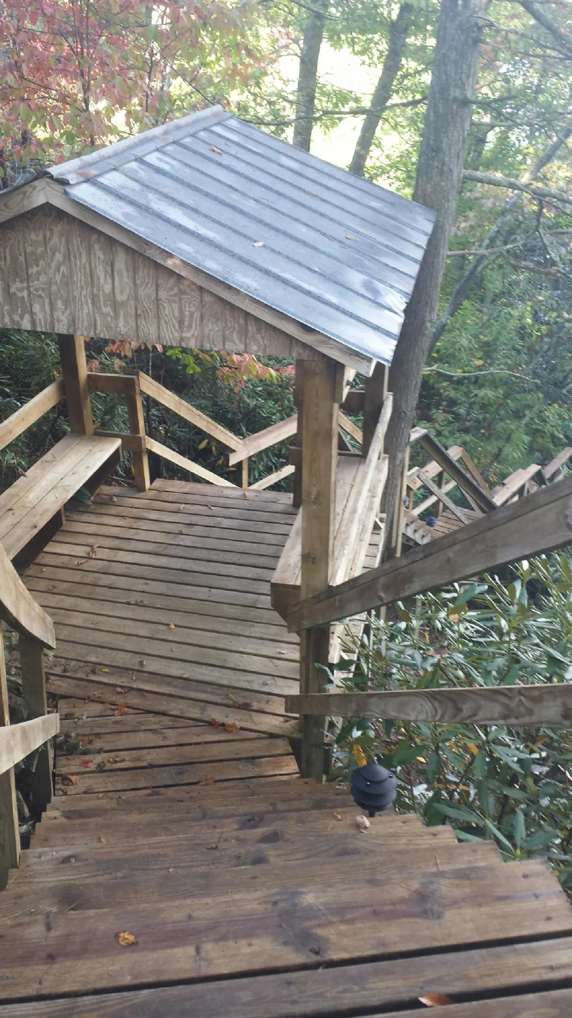 Metal roofed shelter over wooden steps on a wooded walkway — Skylight Repair & Installation work by our crew in Spicer