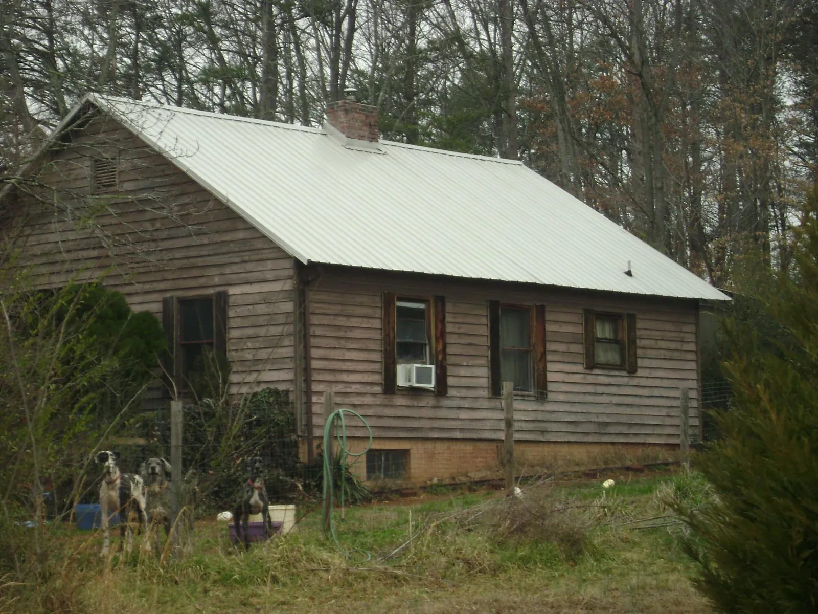 White metal roof on an old wood sided farmhouse, from a Metal Roof Installation job in Spicer